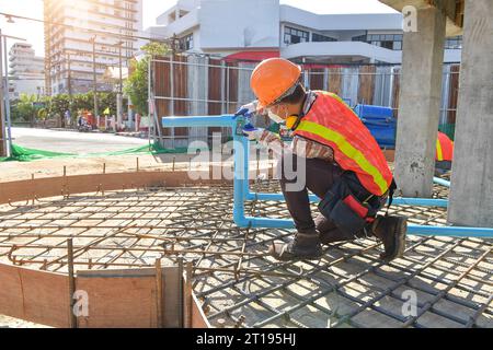 Construction worker using a  Laser measuring tool on a construction site, Thailand Stock Photo