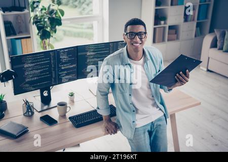 Photo of young handsome entrepreneur guy hold notepad preparing contract terms with customers his it company developers startup in office Stock Photo
