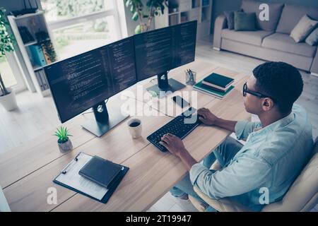 Side view photo of young representative web designer man working on new project coding html css using two monitors in office workplace Stock Photo