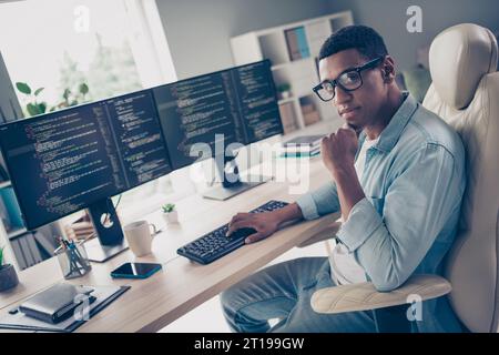 Photo of young man server moderator working at home office typing keyboard touch chin thinking to improve his programming skill indoors Stock Photo