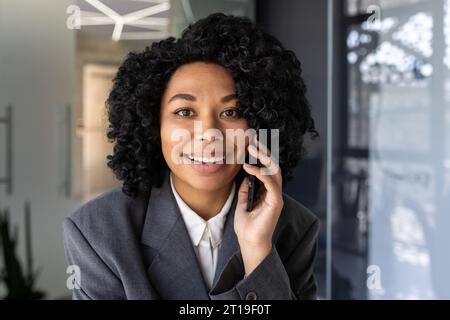 Portrait of a young African American businesswoman working in the office and talking on the phone. Stock Photo
