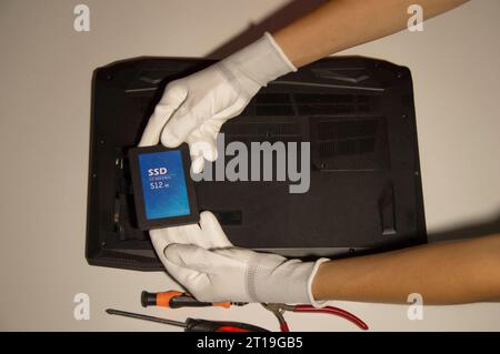 Top view. Technician changing hard disk, SSD, high speed hard disk. Stock Photo