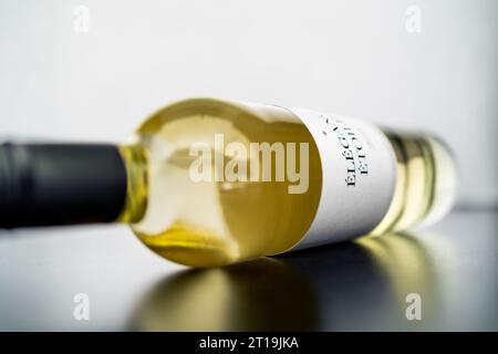 White wine bottle with label and mockup brand. Chardonnay, sauvignon blanc or riesling on table. Vintage alcohol. Premium quality product. Stock Photo