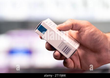 Pharmacy, medicine store and drug shop. Box of medical product. Pharmacist or customer holding paracetamol, ibuprofen or painkiller medication in hand. Stock Photo