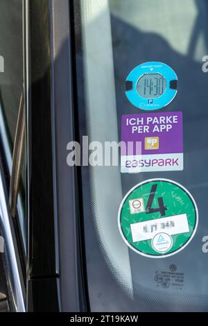 Elektronische Parkscheibe, PKW mit einer digitalen Uhr, die die Ankunft des  Fahrzeugs auf einem Parkplatz anzeigt