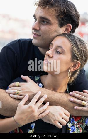 PORTRAIT OF A YOUNG COUPLE RELAXING AT SUNSET, VERTICAL PICTURE Stock Photo