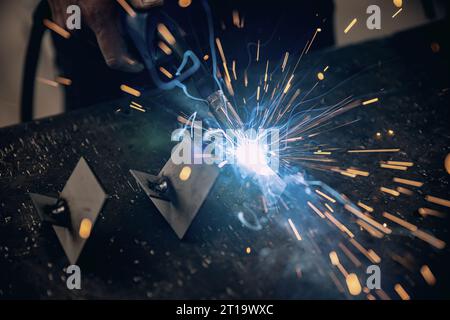 Worker welding the iron. Metal welding with sparks. Stock Photo