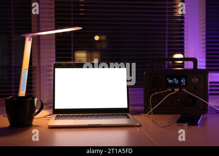Charging station for laptop and desk lamp when there is no light during blackout. Generator power bank battery in the absence of electricity. at home Stock Photo