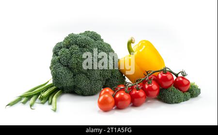 composition of vegetables on a white background: broccoli, green pickle, pepper and cherry tomatoes Stock Photo