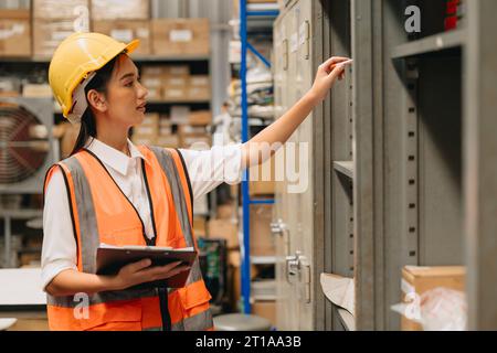 Engineer woman work in hardware products warehouse store using tablet parts inventory management software Stock Photo
