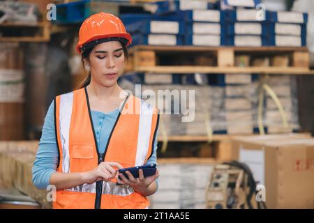 Engineer woman work in hardware products warehouse store using tablet parts inventory management software Stock Photo