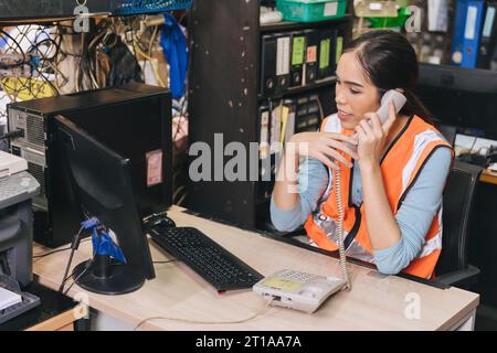 engineer woman technician staff working product parts stock customer support on call in back office desk Stock Photo