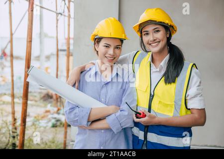 Portrait happy smiling construction Engineer women working team together builder architect designer work at construction site Stock Photo
