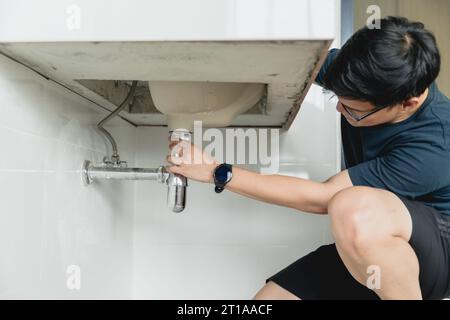 man diy repair sink faucet pipe leak husband working as handyman at home. Stock Photo