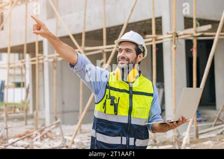 Construction engineer builder work in construction site. Architect home project foreman chief designer happy with laptop computer. Stock Photo