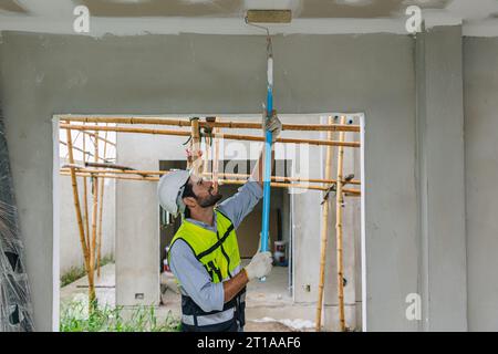 painter worker painting roof work in construction site. contruction worker working interior decoration Stock Photo