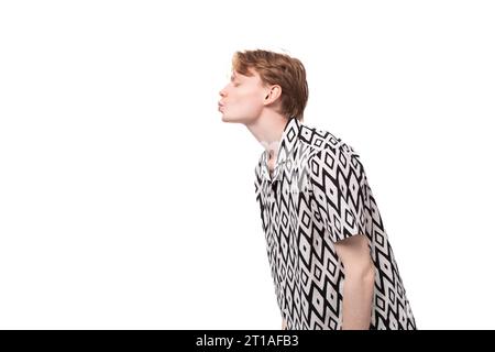 young caucasian man in love with reddish golden hair in a summer shirt sends an air kiss Stock Photo