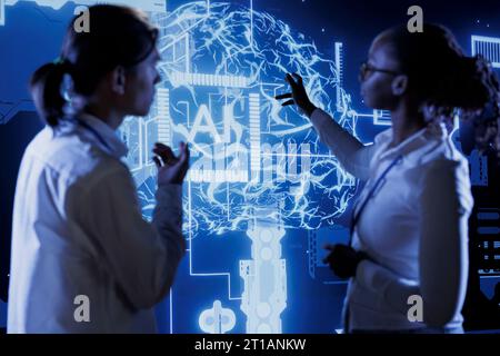 Qualified technicians brainstorm ways to use AI cognitive computing to extract usable information from complex data. Team of specialists implement artificial intelligence to process massive datasets Stock Photo