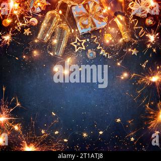New Year Celebration - Lights With Champagne Glasses And Gift Boxes With Golden Ornaments On Blue Background Stock Photo