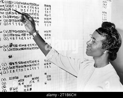 Shirley Chisholm, head-and-shoulders portrait, standing with right arm raised, looking at list of political statistics on wall, New York City, New York, USA, Roger Higgins, New York World-Telegram and the Sun Newspaper Photograph Collection, November 2, 1965 Stock Photo