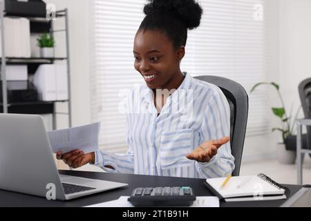 Professional accountant having video chat via computer at desk in office Stock Photo