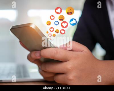 Social media and technology concepts , Human hand is holding a phone and there is a social media icon. Stock Photo