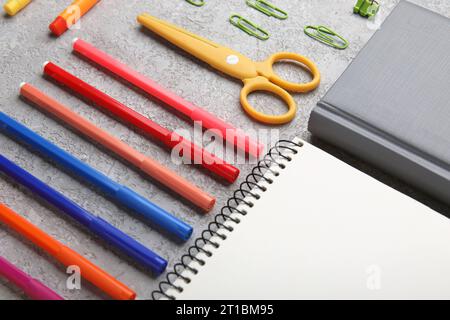 Composition with notebooks, scissors and felt-tip pens on grunge background, closeup Stock Photo