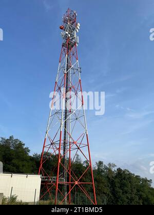 A tall telecommunications tower in stark contrast against the brilliant blue sky Stock Photo