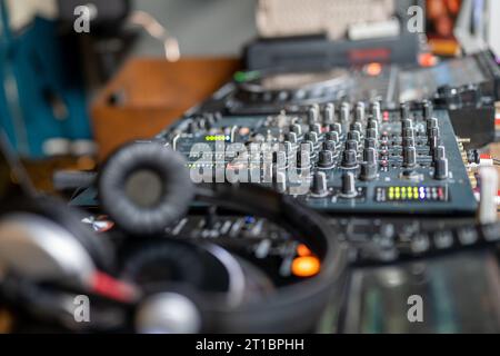 DJ console. Amplifying equipment, studio audio mixer knobs and faders. Music production, creation. Stock Photo