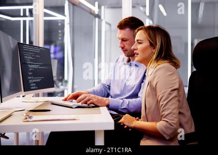 Computer Programmer Writing Program Code On Computer In Office Stock Photo