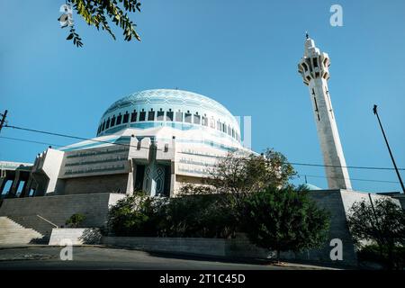 King Abdullah I Mosque in Amman, Jordan. It was built between 1982 and 1989. modern mosque. The tall minaret on the background of blue sky Stock Photo