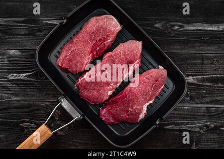 three juicy pieces of meat - barbecue cooking steak in a pan Stock Photo