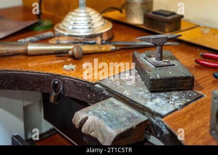 Craft workplace of a jeweler. Jewelry tools and equipment on a goldsmith wooden desk table. Stock Photo