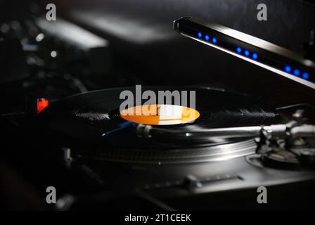 Dj turntables needle cartridge on black vinyl record with music. Close up, nobody, focus on turntable and audio disc record Stock Photo