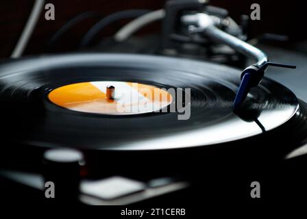 Dj turntables needle cartridge on black vinyl record with music. Close up, nobody, focus on turntable and audio disc record Stock Photo