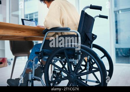 Business, desk and worker in wheelchair in office, working on project, report and inclusion. Corporate, professional and person with disability with Stock Photo