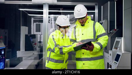 Factory Engineers In Helmets. Checking Industrial Facility Stock Photo