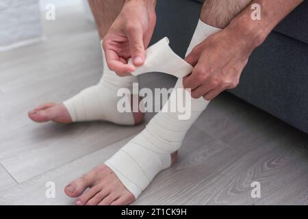 man using put on elastic bandage with legs having leg pain Stock Photo