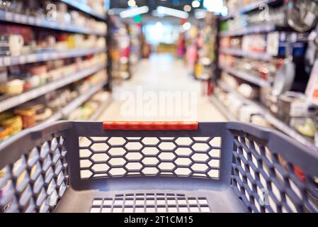 Abstract blurred photo of empty trolley in supermarket bokeh background. Empty shopping cart in supermarket. Stock Photo