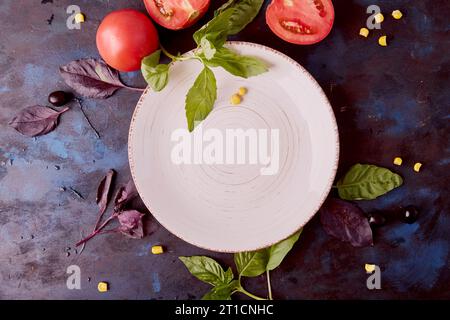 Aesthetics empty white plate mockup in the center among organic vegetables and greens. Keto, FODMAP, Paleo, Plant-based diet concept top view. Stock Photo