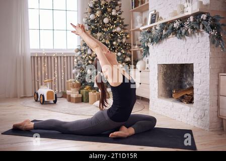 Young attractive woman practicing yoga at modern home Stock Photo