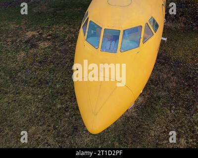 aerial view from drone of a small old jet yellow passenger plane cockpit standing in a field, nobody Stock Photo