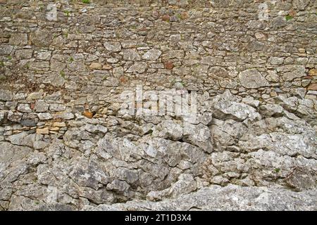 Medieval wall, consisting of rough-hewn stones, built on rock Stock Photo