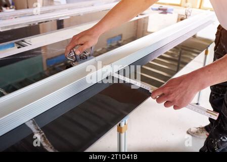 Construction worker cutting ceramic tiles using ceramic cutter Stock Photo