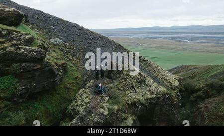 People hike on mountain above valley of green and cloud Stock Photo