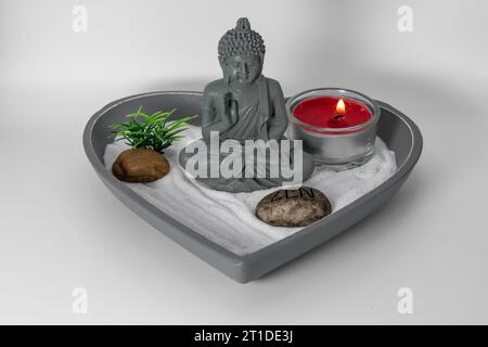 Zen garden. Spiritual Buddha decoration for a serene, calm and strong concentration atmosphere. Candle that releases aromas in a relaxing oasis. Stock Photo