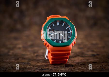 Orange bright wrist watch on wooden background closeup Stock Photo