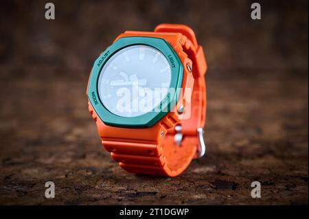 Orange bright wrist watch on wooden background closeup Stock Photo