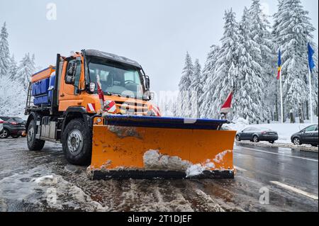Snowplow removing the snow from the road in mountains Stock Photo