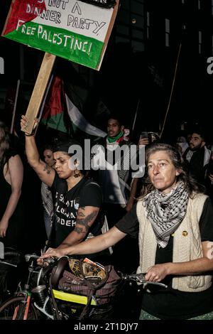 An activist holds a placard during the demonstration. Two days of demonstrations have taken place in Dublin by members of the Palestinian community as well as supporters from various diaspora and by locals and activist groups in a show of solidarity in light of recent strikes on Gaza by Israeli military forces. Protestors gathered in Dublin City centre, at government buildings and marched to the Israeli Embassy where speeches were made by members of the Palestinian community, students, activists and members of Irish political socialist party People Before Profit. Stock Photo